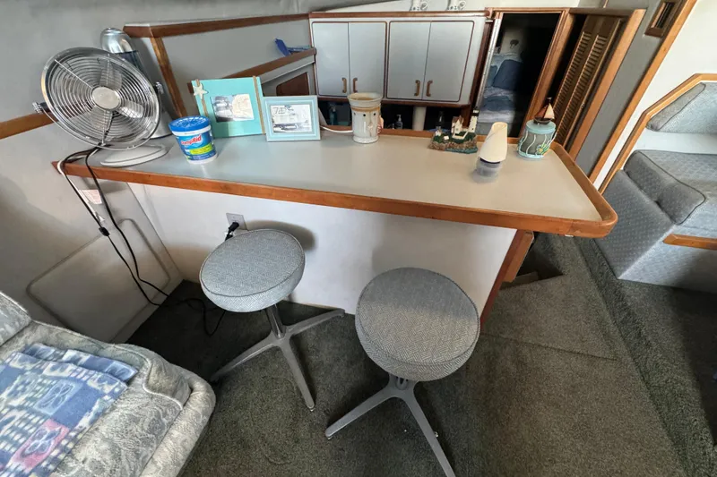 Interior of 1990 Sea Ray 380 Aft Cabin with bar stools and decor.