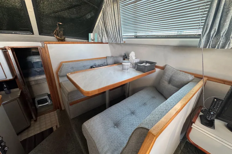 1990 Sea Ray 380 Aft Cabin interior with cozy dining area and cushioned seating.
