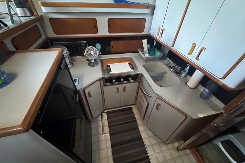 1990 Sea Ray 380 Aft Cabin kitchen with cabinets, sink, and appliances.