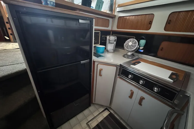1990 Sea Ray 380 Aft Cabin kitchen with fridge, stove, and appliances.