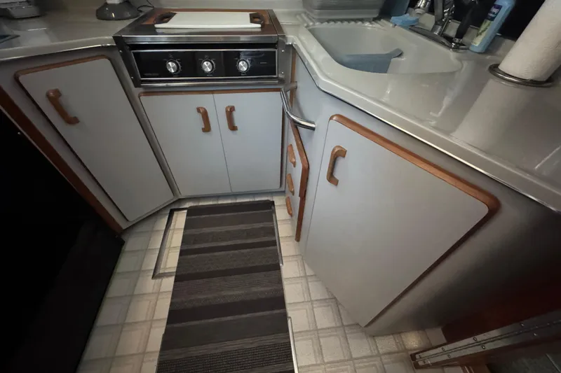 1990 Sea Ray 380 Aft Cabin kitchen with stove, sink, and cabinets.