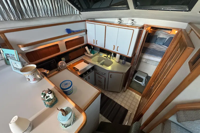 1990 Sea Ray 380 Aft Cabin interior with kitchen and cozy sleeping area.