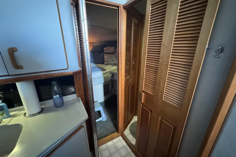 1990 Sea Ray 380 Aft Cabin interior with wooden cabinets and cozy bedroom.