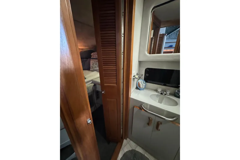 1990 Sea Ray 380 Aft Cabin interior with bathroom and cozy bedroom view.