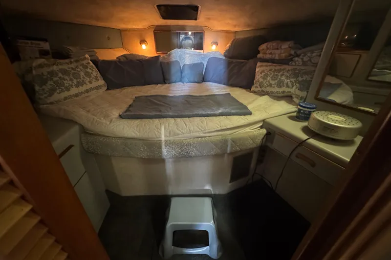 Cozy 1990 Sea Ray 380 Aft Cabin bedroom with soft lighting and plush bedding.