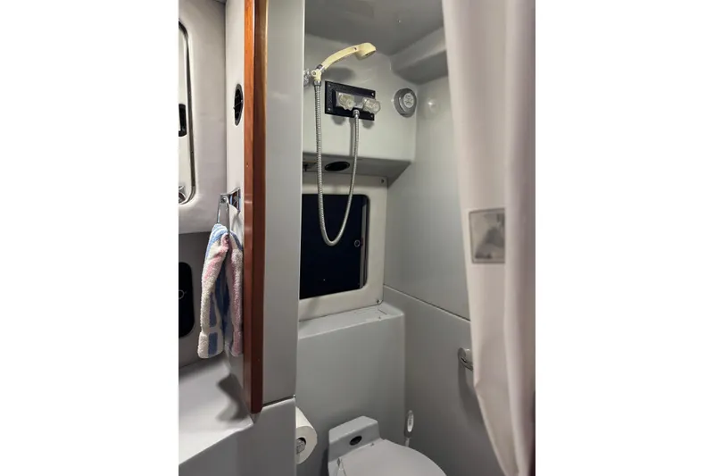 1990 Sea Ray 380 Aft Cabin bathroom with shower, window, and towel rack.