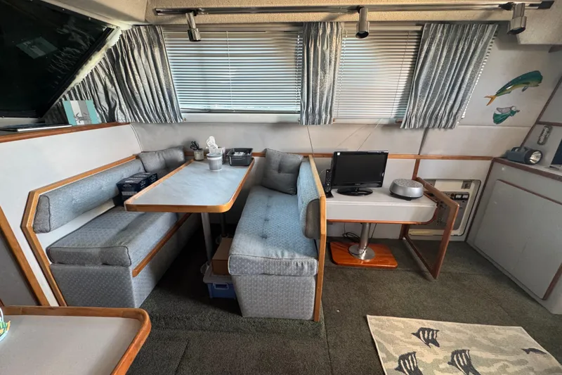 1990 Sea Ray 380 Aft Cabin interior with dining area and small TV setup.