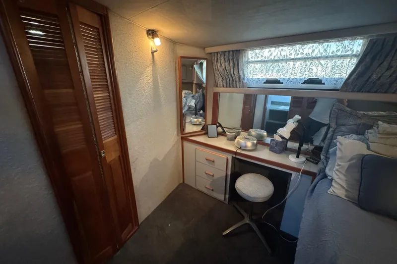 1990 Sea Ray 380 Aft Cabin interior with vanity, mirror, and cozy decor.