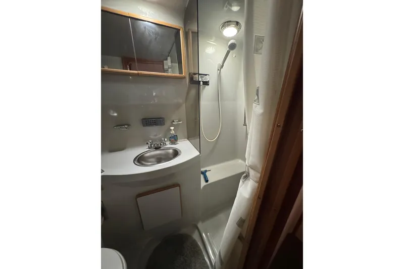 1990 Sea Ray 380 Aft Cabin bathroom with shower, sink, and mirror.