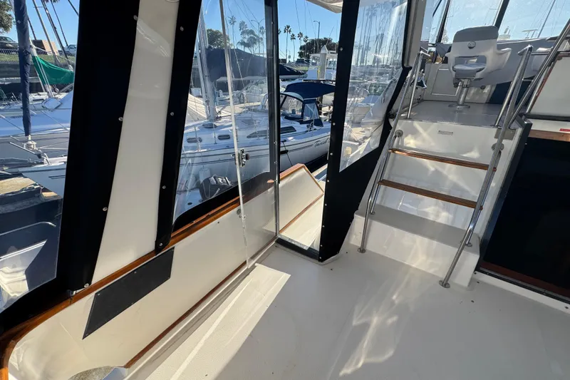 1990 Sea Ray 380 Aft Cabin interior with marina view, featuring stairs and seating area.