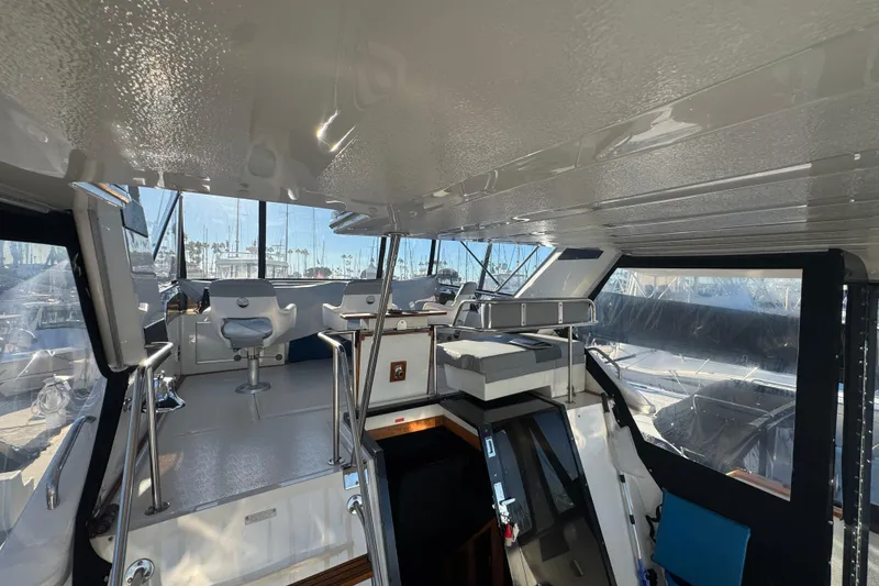 1990 Sea Ray 380 Aft Cabin interior with helm, seating, and marina view.