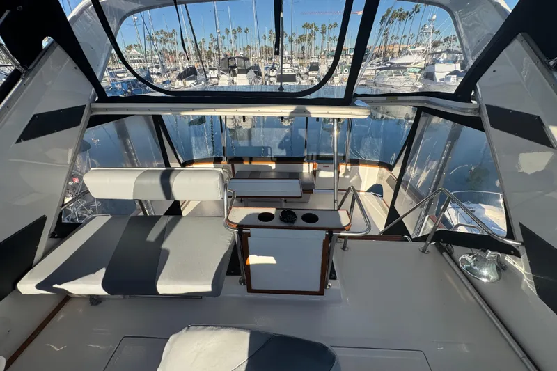 1990 Sea Ray 380 Aft Cabin interior with marina view, featuring seating and helm area.