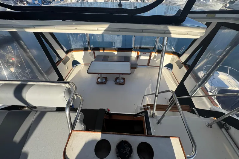 1990 Sea Ray 380 Aft Cabin yacht interior with seating and table, enclosed by clear panels.