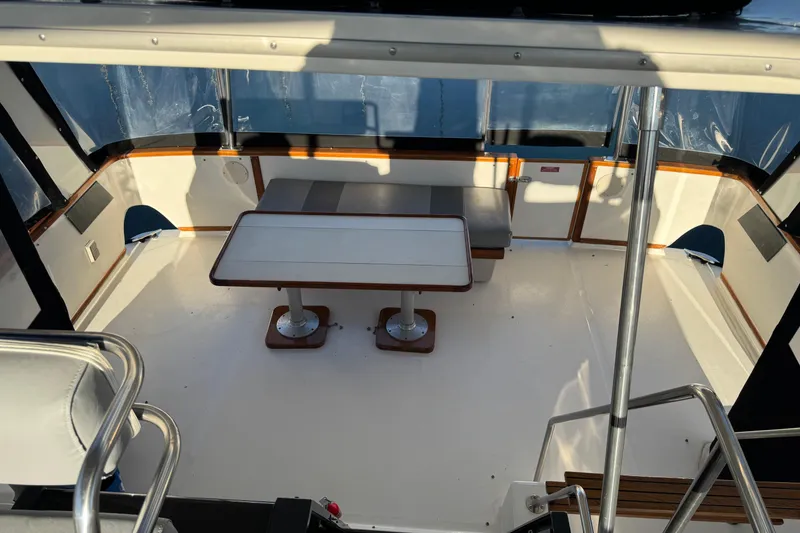 1990 Sea Ray 380 Aft Cabin interior with seating and table, featuring wood accents.