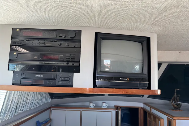 1990 Sea Ray 380 Aft Cabin interior with vintage Panasonic TV and audio system.