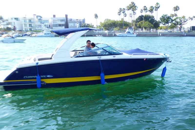 2018 Chaparral 267 SSX boat cruising on a sunny day near waterfront homes.