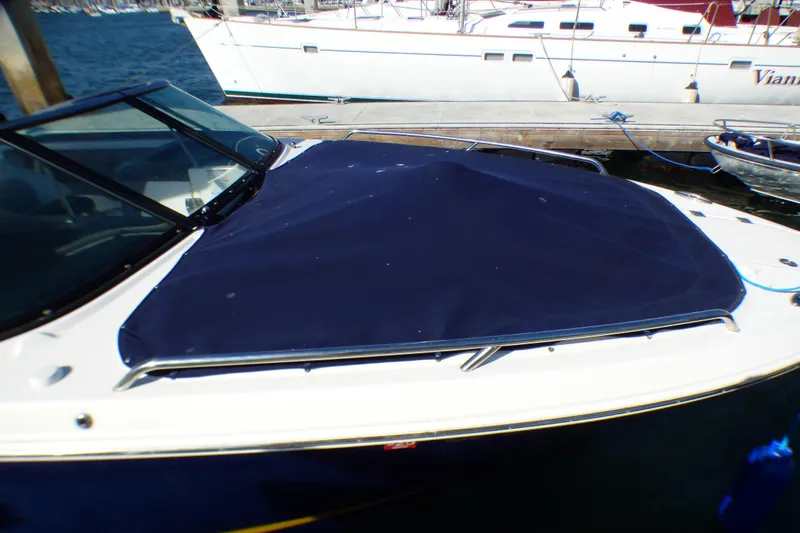 2018 Chaparral 267 SSX boat with blue cover docked at marina.