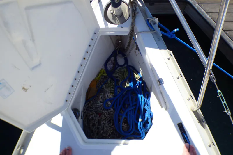 Open anchor locker on 1994 Hunter Legend 35.5 sailboat with ropes and chains.