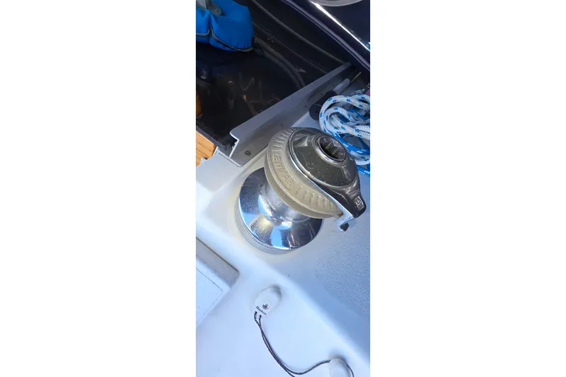Winch on 1994 Hunter Legend 35.5 sailboat deck with coiled rope.