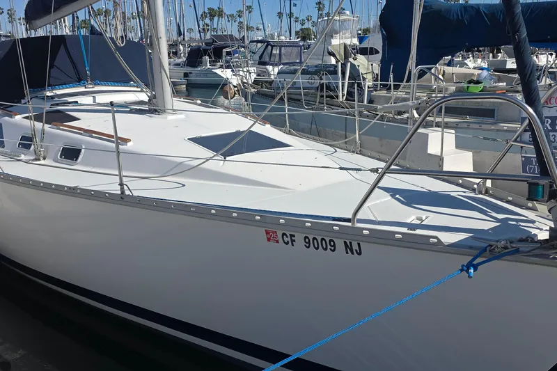 1994 Hunter Legend 35.5 sailboat docked in marina, surrounded by other boats.