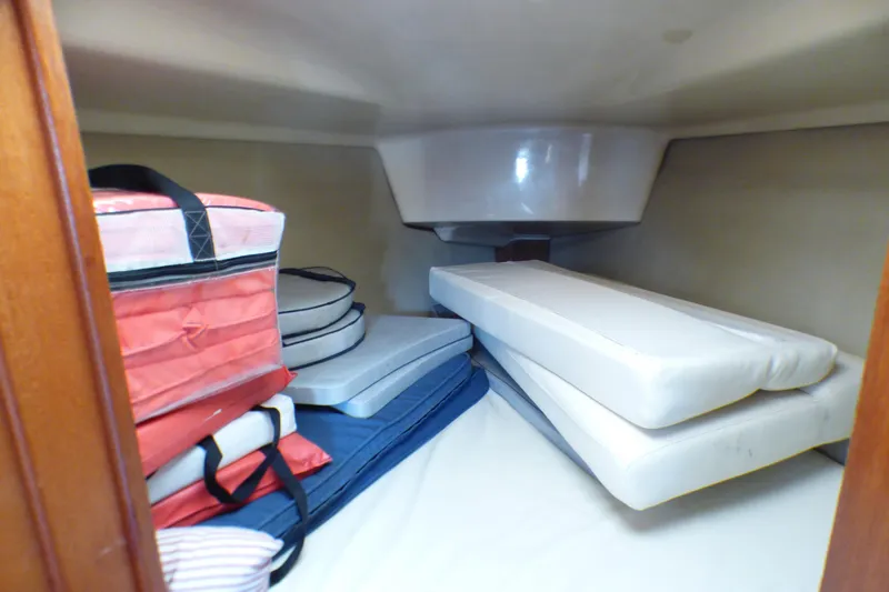 Interior cabin storage of 1994 Hunter Legend 35.5 sailboat with cushions and bags.