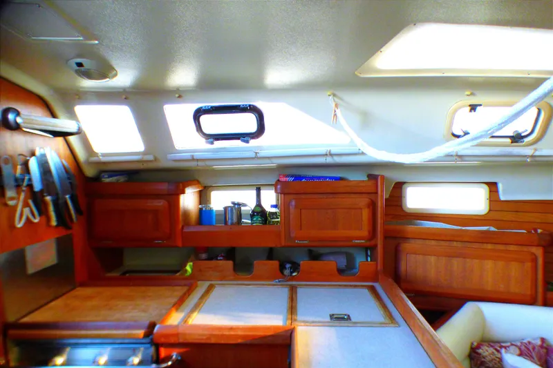 Interior of 1994 Hunter Legend 35.5 sailboat, featuring wooden cabinetry and kitchen area.