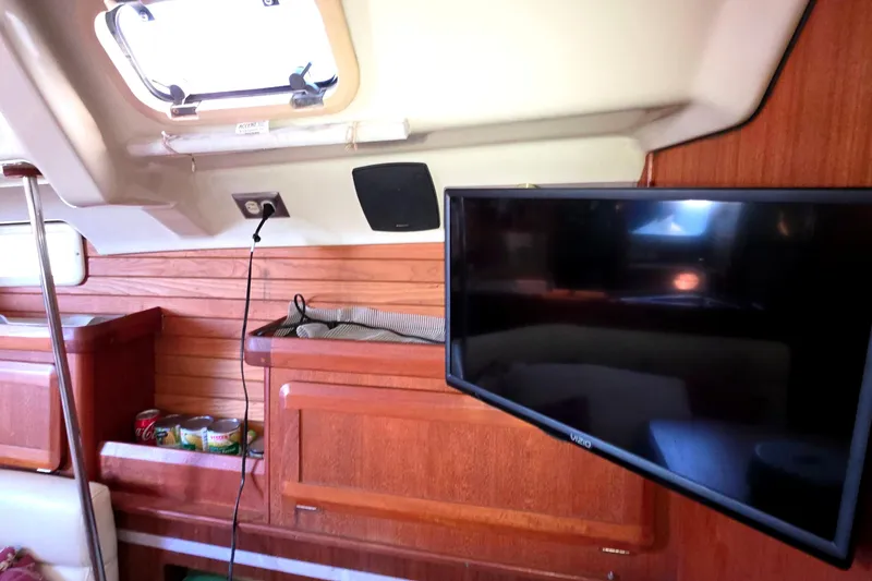 Interior of 1994 Hunter Legend 35.5 yacht with TV and wooden cabinetry.