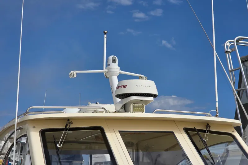 2005 Mainship 34 Pilot Sedan Rum Runner II with radar equipment against blue sky.
