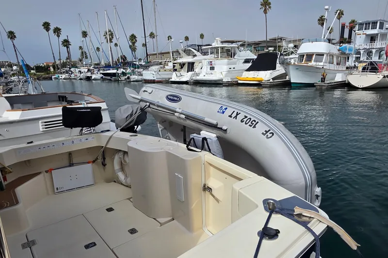 2005 Mainship 34 Pilot Sedan Rum Runner II docked in a marina with inflatable boat.
