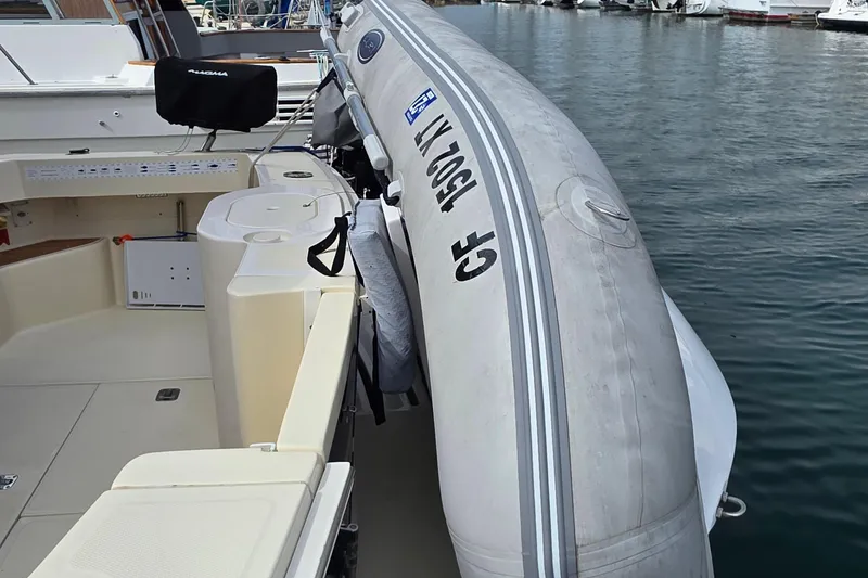 2005 Mainship 34 Pilot Sedan Rum Runner II with inflatable boat docked at marina.