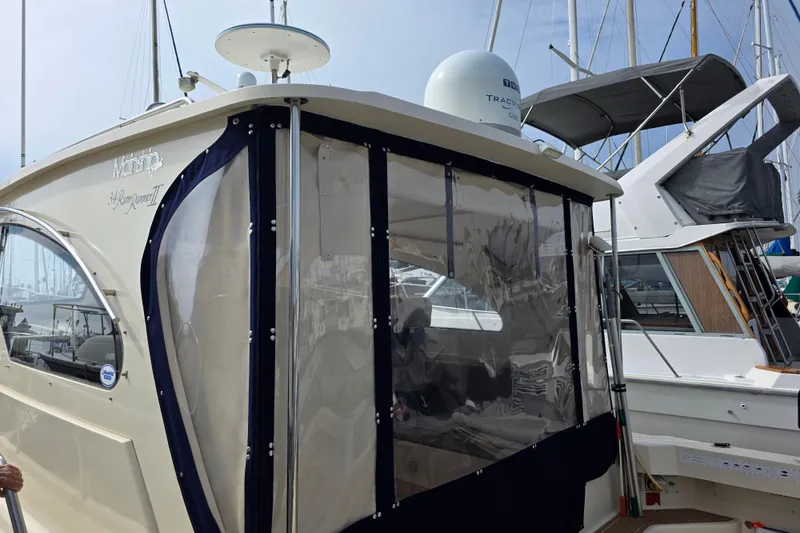 2005 Mainship 34 Pilot Sedan Rum Runner II docked at marina, featuring enclosed cabin.