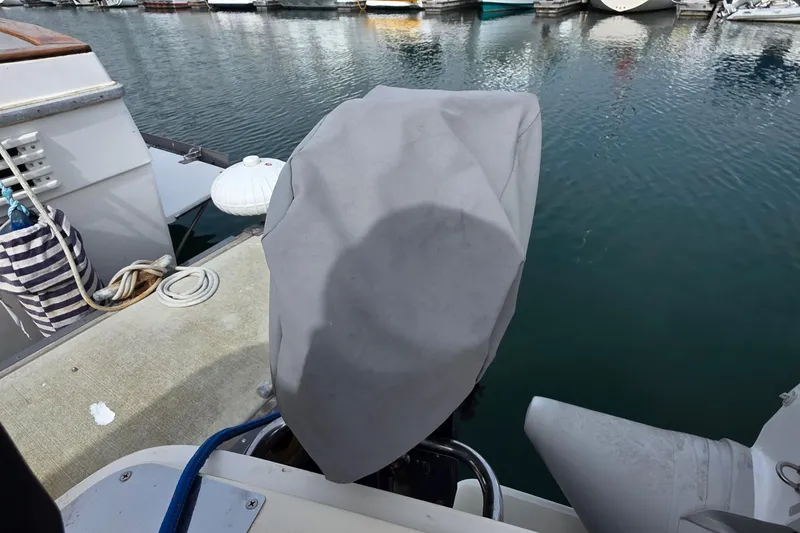 Covered outboard motor on a 2005 Mainship 34 Pilot Sedan Rum Runner II at a marina.