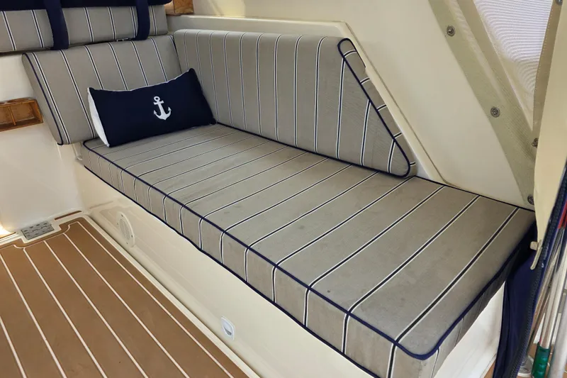 2005 Mainship 34 Pilot Sedan Rum Runner II interior with striped seating and anchor pillow.