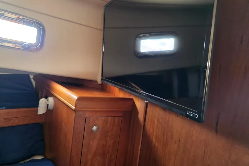 Interior of 2005 Mainship 34 Pilot Sedan Rum Runner II with TV and wooden cabinetry.