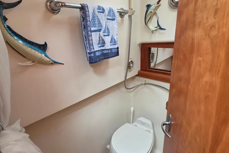 2005 Mainship 34 Pilot Sedan bathroom with nautical decor and towel rack.