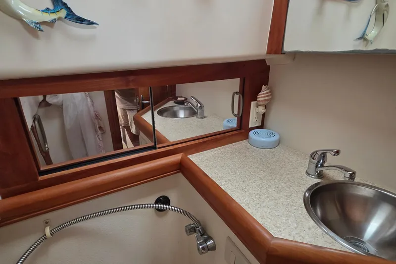 2005 Mainship 34 Pilot Sedan Rum Runner II bathroom with sink, mirror, and countertop.