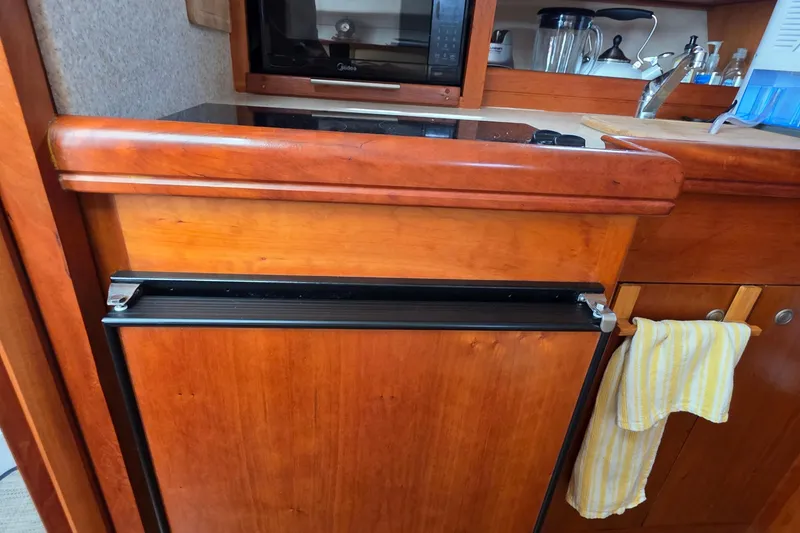 2005 Mainship 34 Pilot Sedan Rum Runner II galley with wood cabinetry and appliances.