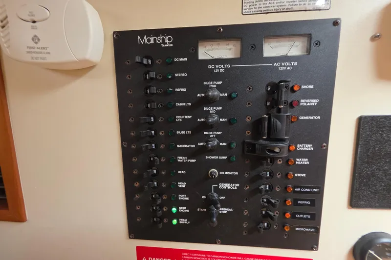 Control panel of 2005 Mainship 34 Pilot Sedan Rum Runner II boat, featuring various switches and indicators.