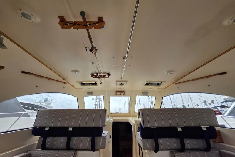 Interior of 2005 Mainship 34 Pilot Sedan Rum Runner II with striped seating and large windows.
