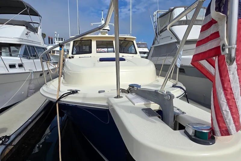 2005 Mainship 34 Pilot Sedan Rum Runner II docked, featuring American flag and anchor.