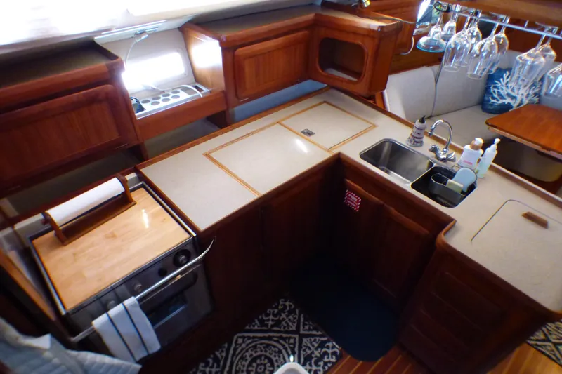 1993 Hunter 40.5 yacht kitchen with wooden cabinetry, dual sink, and modern appliances.