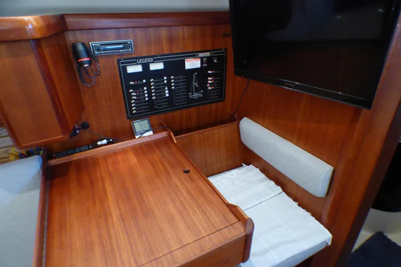 Navigation station of 1993 Hunter 40.5 sailboat with control panel and seating area.