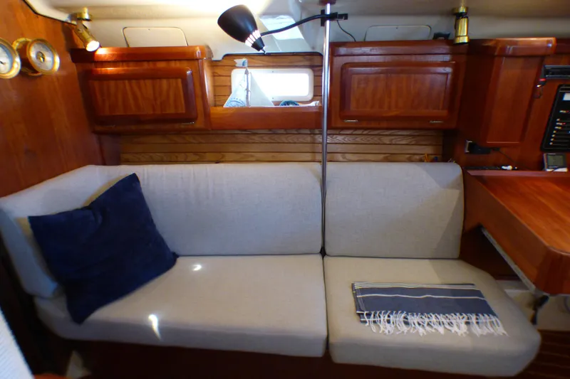 Cozy interior of 1993 Hunter 40.5 sailboat with sofa and wooden cabinetry.