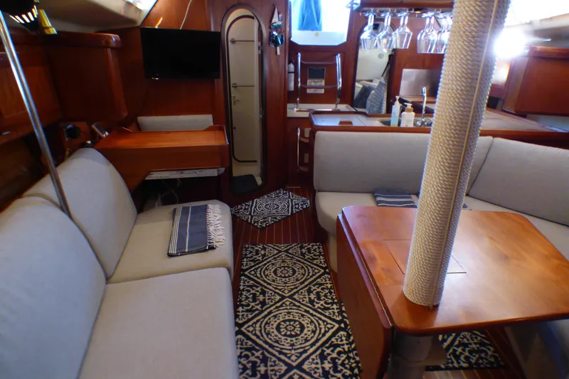 Interior of a 1993 Hunter 40.5 sailboat with cozy seating and elegant wood finishes.