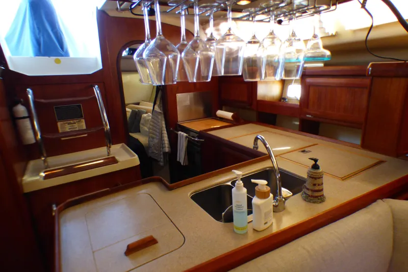 Luxurious 1993 Hunter 40.5 yacht interior with kitchen, sink, and hanging glassware.