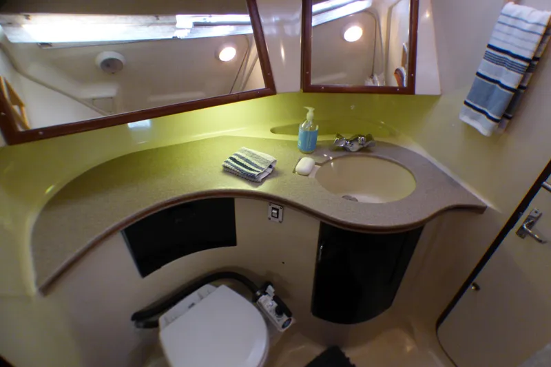 Bathroom interior of 1993 Hunter 40.5 yacht with sink, mirror, and toilet.