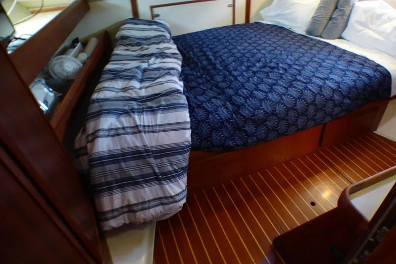 Cozy cabin interior of 1993 Hunter 40.5 sailboat with wooden flooring and comfortable bedding.