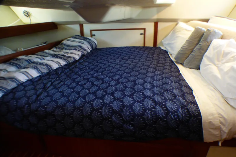 Cozy cabin bed in 1993 Hunter 40.5 sailboat with patterned bedding and pillows.
