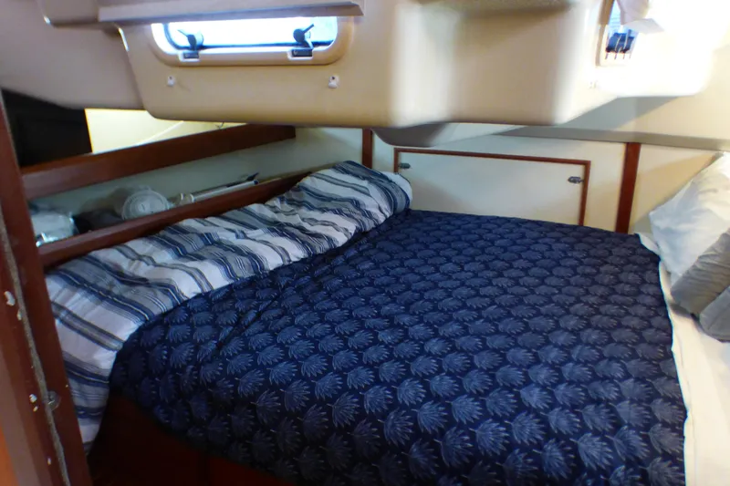 Cozy cabin interior of 1993 Hunter 40.5 sailboat with patterned bedding.