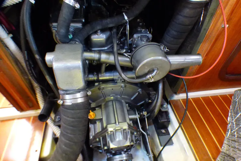 Engine compartment of a 1993 Hunter 40.5 sailboat, showcasing mechanical components and hoses.
